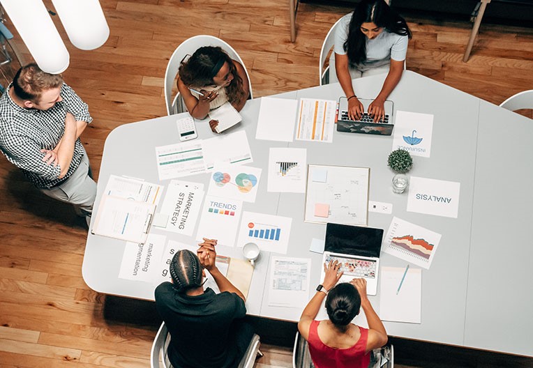 People sat around a table in the office discussing a project