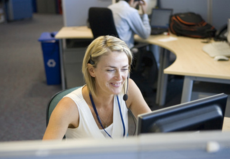 Image of a woman taking a call at her desk