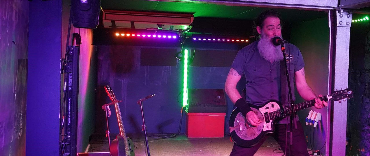 Dave Arcari playing his guitar on stage to a live audience