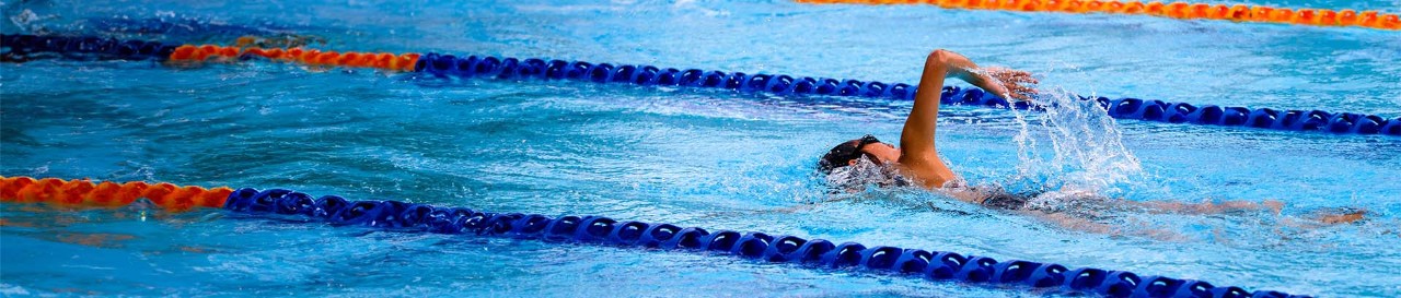 A male swimmer in a public swimming pool