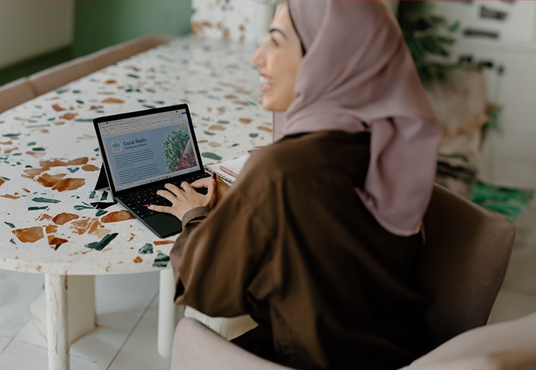 Woman using laptop on the desk and smiling