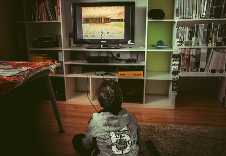 Boy sitting on the floor in front of TV in the living room