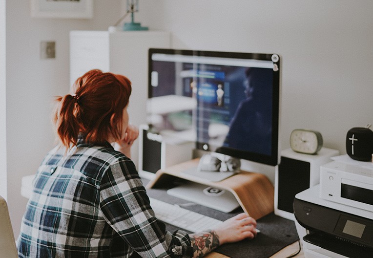 A person working from home using her computer on a desk