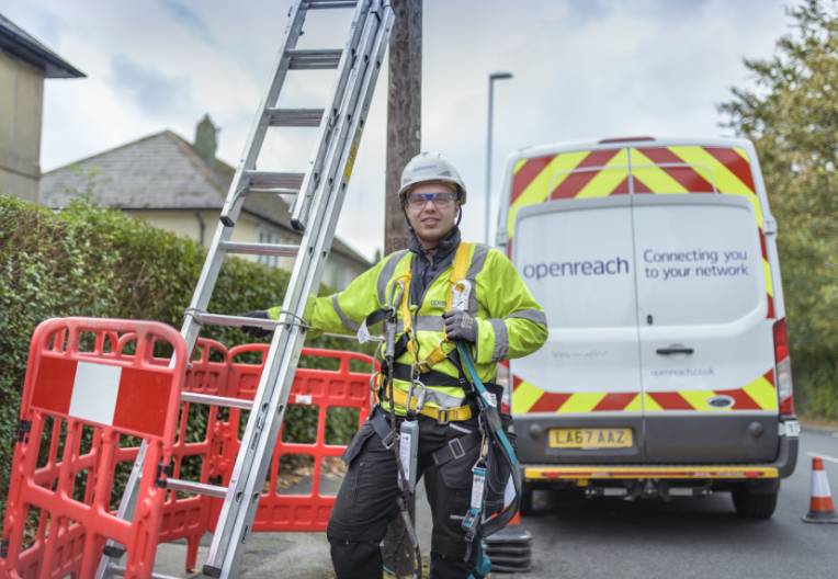 Image of an engineer getting ready to climb a pole