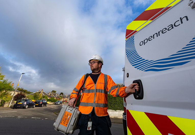 Openreach engineer standing next to branded van in East England community 