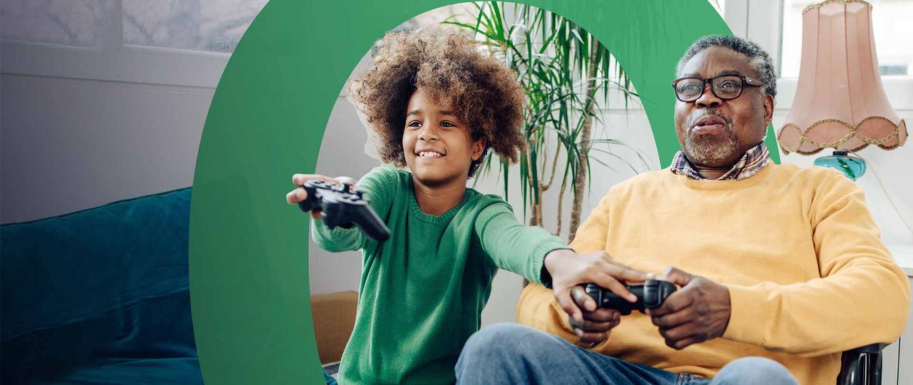 Man and young boy holding console controllers and playing video games