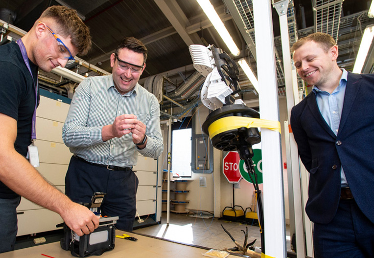 Image of Miles Briggs watching an engineer splice fibre