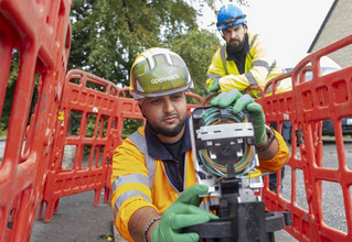 Two adults and a child smiling and playing on a tablet