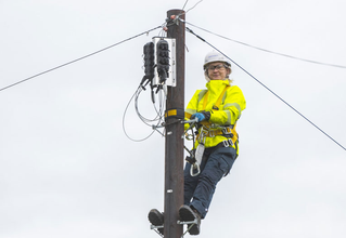Two women sitting on a couch talking with a laptop